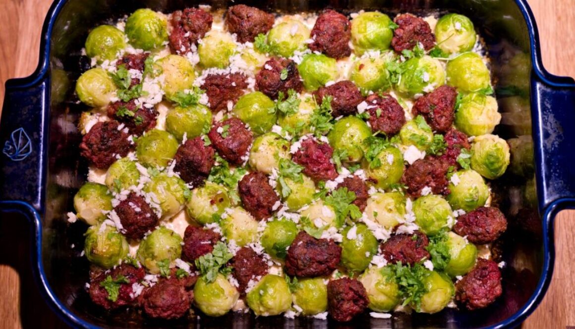 Minced meat and beetroot balls with Brussels sprouts in cheese sauce